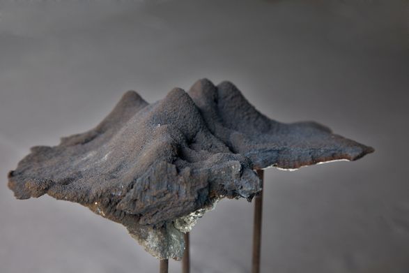 <i>Disc Cutter Landscape 4</i>, congealed  iron dust, steel posts, wooden base, 30 X 30cm. Photo: Aled Rhys Huws